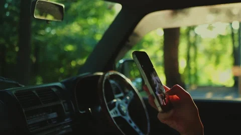 Close-up of a hand holding a smartphone inside a parked car in... Stock Footage 341613119