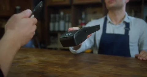 Close Up of a Hand Holding a Smartphone with an NFC Payment Technology Used for Stock Footage 157654895
