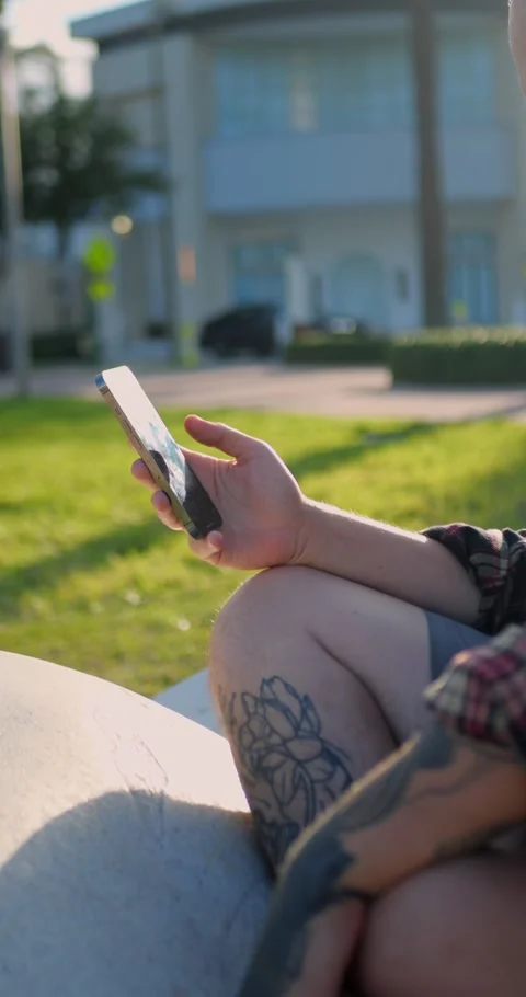 Close-Up Of Hand Holding Smartphone While Sitting Outdoors... Stock Footage 333525124