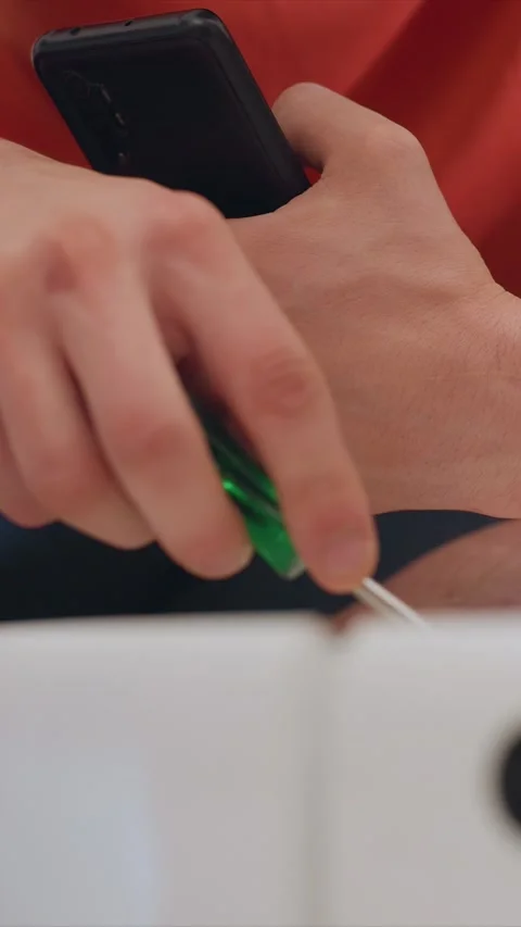 Close up of hand holding smartphone while using tool on open book with Vídeo Stock 346786959