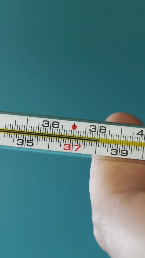 Close-up of a hand holding a thermometer showing a normal temperature reading Stock-Footage 343838109