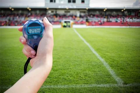 Close up of a hand holding a timer against pitch Stock Photos