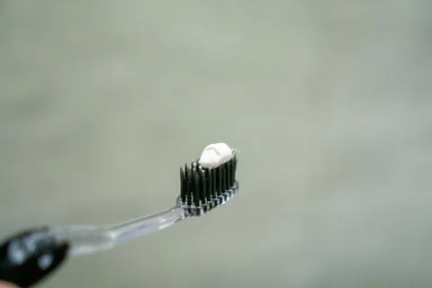 Close up of a hand holding a toothbrush with a toothpaste on the top. Oral .. Stock Photos