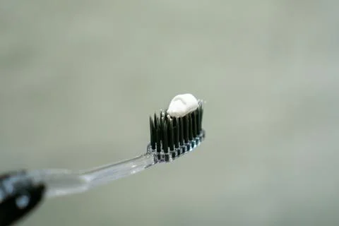 Close up of a hand holding a toothbrush with a toothpaste on the top. Oral .. Stock Photos