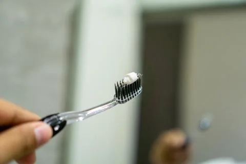 Close up of a hand holding a toothbrush with a toothpaste on the top. Oral .. Stock Photos
