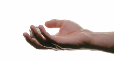 Close-up of a hand holding a transparent robot on a white background Stock Footage 293674557