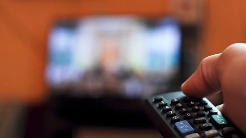 A close-up hand holding a TV remote control Stock Footage 321187997
