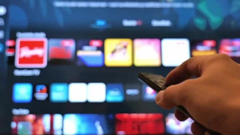 Close Up of Hand Holding TV Remote Controller while Browsing Streaming Menu Stock Footage 342868576