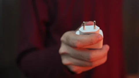 Close Up of Hand Holding Two Pin Power Charger Plug with Blurred Background Stock-Footage 337847375