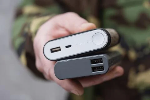 Close up hand holding two portable power banks with usb charging ports. Con.. Stock Photos