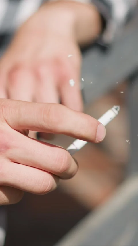 Close up of hand holding unlit cigarette with visible skin texture and redness Stock Footage 345050905