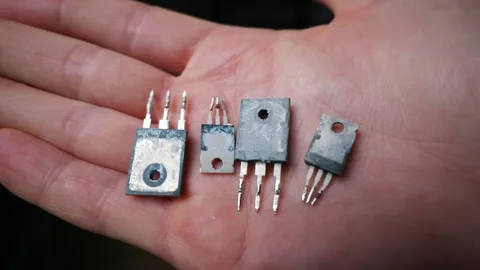 Close Up of Hand Holding Used Electronic Transistors with Thermal Paste Stock Footage 339364179