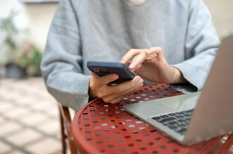 Close up of a hand holding using phone looking at social media watching vid.. Stock Photos