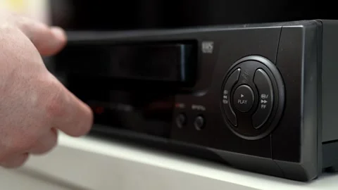 Close up of a hand holding a videotape. Retro vhs cassete in a player. Stock Footage 286426528