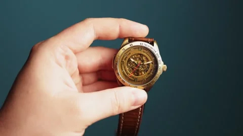 Close-up of a hand holding a vintage mechanical wristwatch with a leather strap Stock Footage 340265587