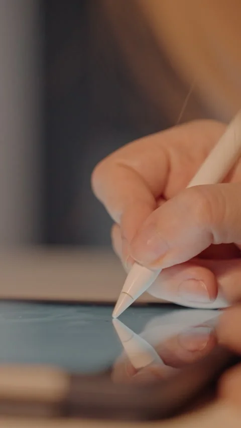 Close up of hand holding white digital pens interacting with tablet screens in Stock Footage 344428131