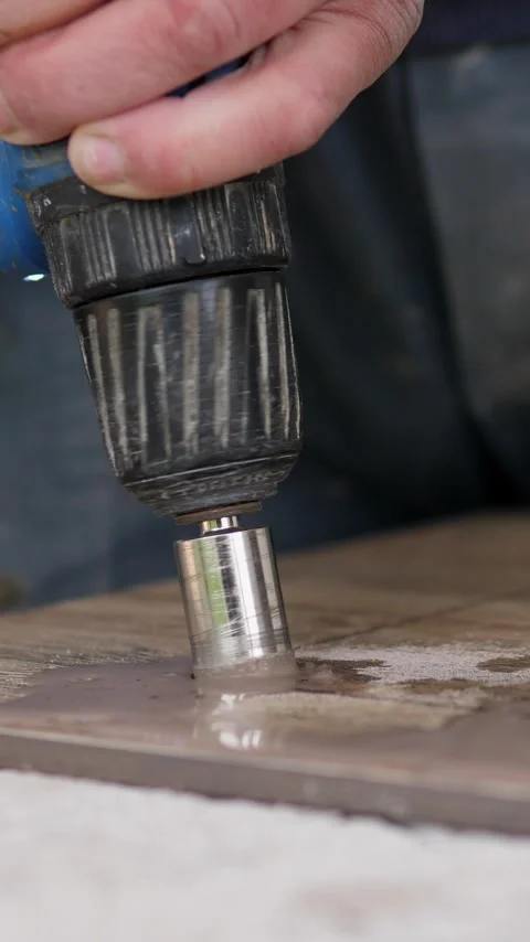 Close-up hand holds blue power drill with metal hole saw pressing into wooden Stock Footage 344824542