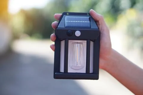 Close up hand holds  mini lantern solar cell. Concept, electrical equipment, gen Stock Photos
