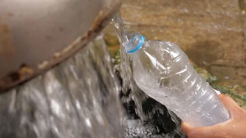 Close-Up, The Hand Holds Plastic Bottle And Pours Pure Water In The Source Video stock 80708065