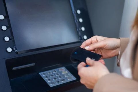 Close up of hand inserting bank card into ATM machine, modern banking Stock Photos