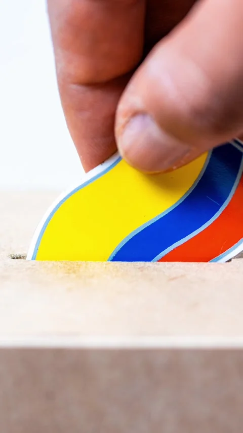 Close up of hand inserting a colorful Colombian flag into a cardboard ballo.. 動画素材 335967079