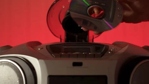 A close-up of a hand inserting a compact disc CD into the open tray of an o.. Stock Footage 315019603