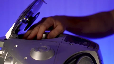 A close-up of a hand inserting a compact disc CD into the open tray of an o.. Stock Footage 315019607