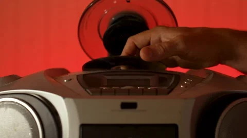 A close-up of a hand inserting a compact disc CD into the open tray of an o.. Stock Footage 315019623