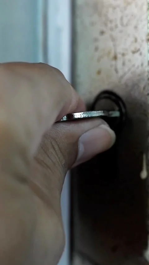 Close-up of a hand inserting a key into an old rusty door Stock Footage 320347390