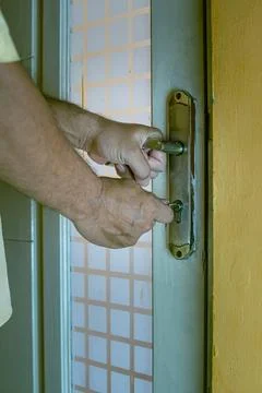 Close-up of a hand inserting a key into an old rusty door lock Stock Photos
