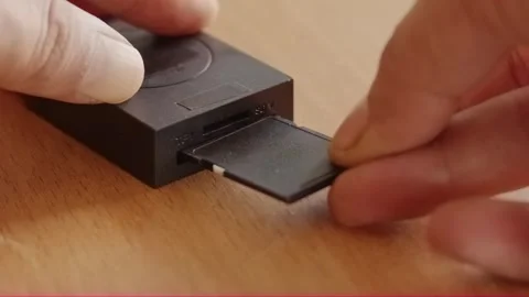 Close-up hand inserting memory card into black card reader Stock Footage 320128278