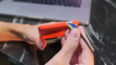 Close-up of hand inserting Micro USB cable into smartphone charging port Stock Footage 333650352