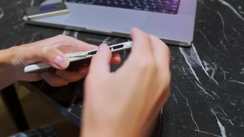 Close-up of hand inserting microSD memory card into smartphone slot, expanding Stock Footage 333650339