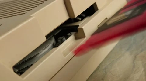 Close-up hand inserting plastic pink floppy disk in  retro style personal com Stock Footage 53816953
