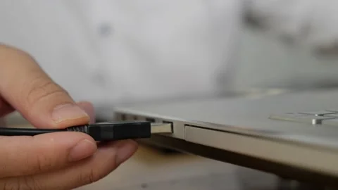Close up of hand inserting plugging data cable into usb port in laptop; data  Stock Footage 149951677