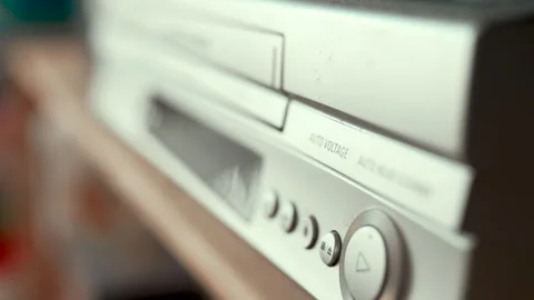 Close up of a hand inserting a VHS video cassette into a vintage VCR player, 4K  Video stock 330677420