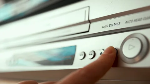 Close up of a hand inserting a VHS video cassette into a vintage VCR player, 4K  Video stock 330677580