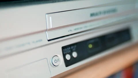 Close up of a hand inserting a VHS video cassette into a vintage VCR player, 4K  Stock Footage 330678160