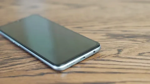 Close-up of a The Hand Inserts the Cord from the Charger into the Phone. The Han Stock Footage 153520495