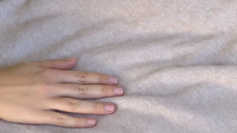 Close-up of hand interacting with beige wool-cashmere textile emphasizing Stock Footage 332875769