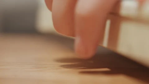 Close up hand interacting with plastic container latch on wooden surface with Stock Footage 345806073