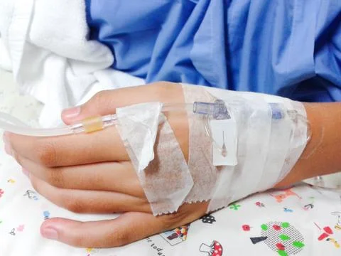 Close up of hand with  IV solution in a patients in hospital with saline intr Stock Photos