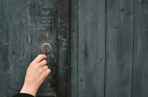 Close up of hand with key opening lock on the wooden door Stock Photos