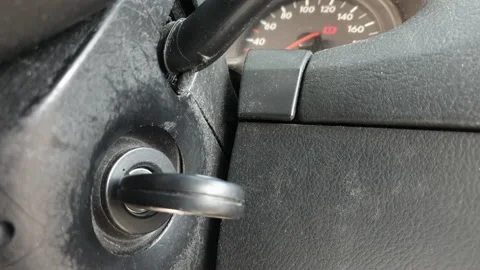 Close-up of a hand with a key starting and shutting down an old car. Selectiv Stock Footage 154427235