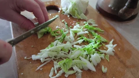 Close up of hand with knife, chopped white cabbage on wooden board Stock-Footage 270380531