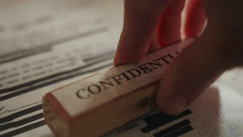 Close up - hand labels redacted document as confidential with red ink stamp Stock Footage 242424995