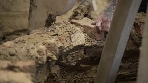 Close Up Hand Laying Brick in Bell Casting Mold, Shallow Focus, Static Stock Footage 220903572