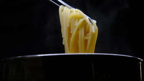 Close-up of hand lifting boiled steamed spaghetti pasta with tongs. Stockbeeldmateriaal 179289696