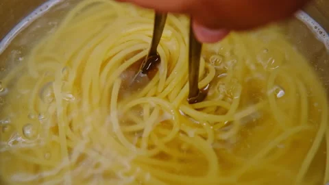 Close-up of hand lifting boiled steamed spaghetti pasta with tongs. Vídeo Stock 179291500