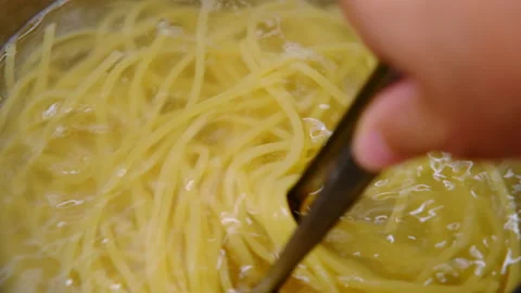 Close-up of hand lifting boiled steamed spaghetti pasta with tongs. Stock Footage 179300769